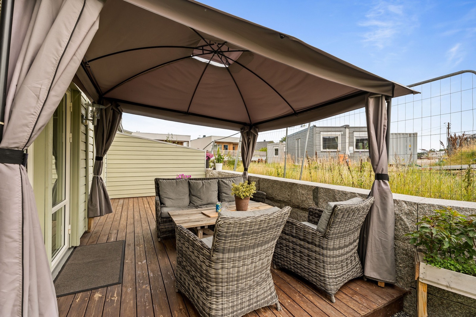 Sydvendt terrasse med utgang fra stuen. Det er planlagt oppføring av eneboliger på nabotomten. Galleribilde