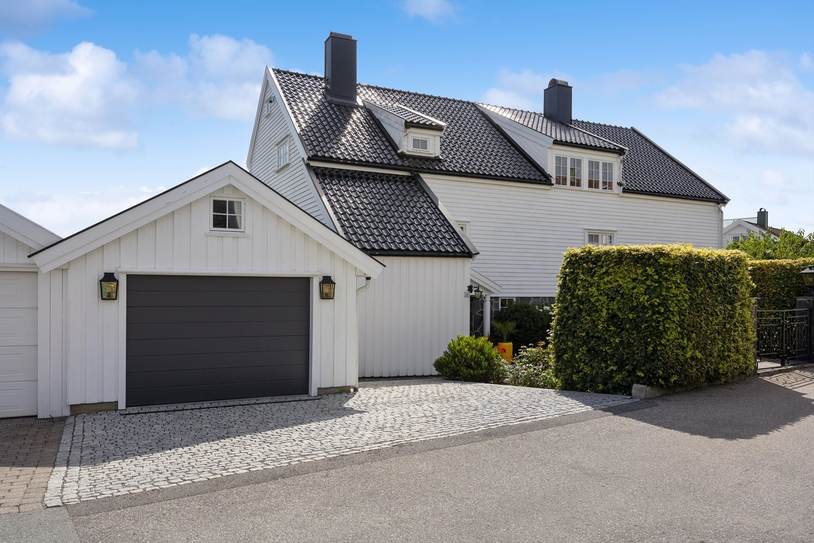 Innbydende gårdsplass med brostein og fin stensetting, samt smijernsport. Galleribilde