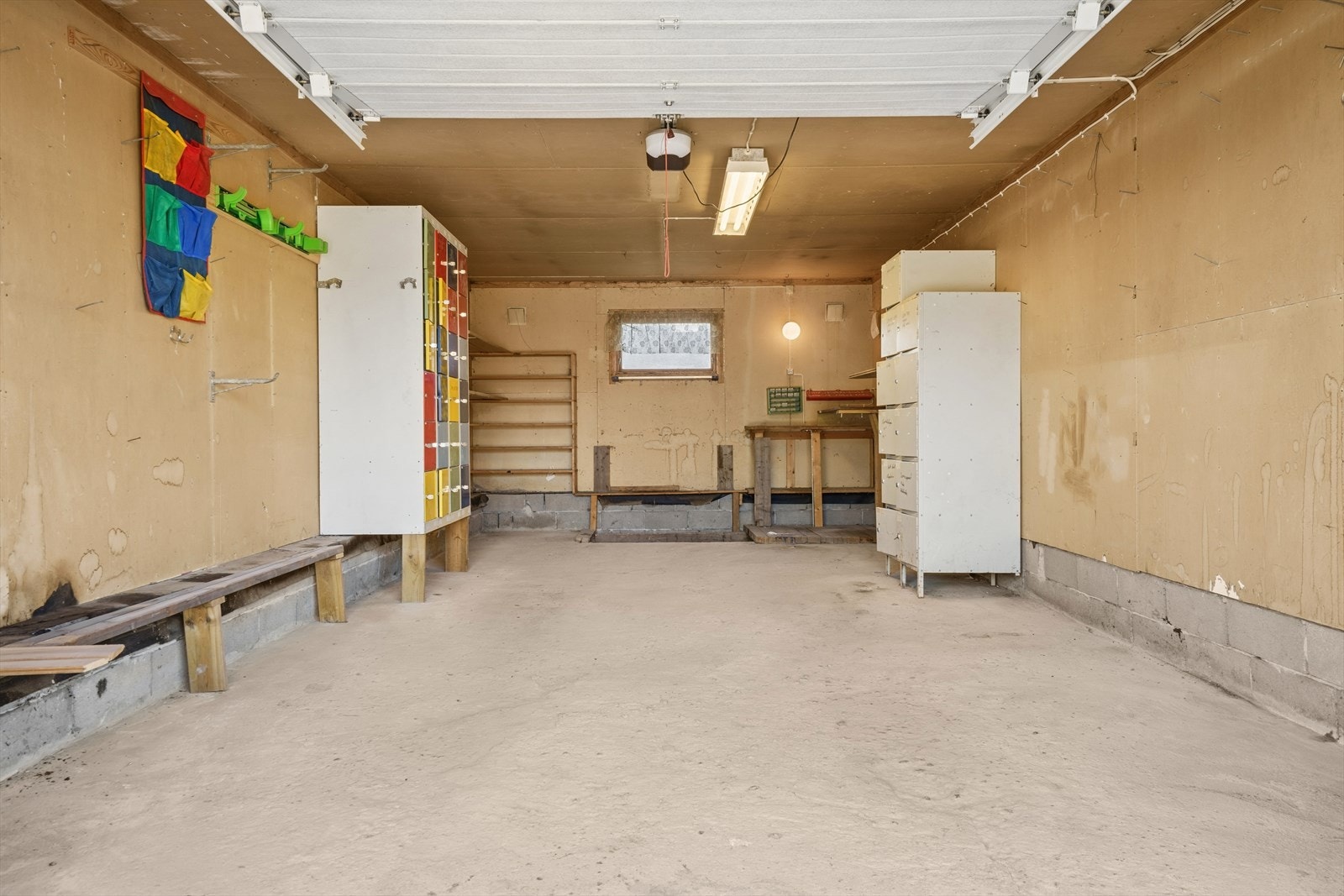 Parkering kan gjøres i en inntilbygget garasje med leddport og elektrisk motor, samt på den grusede gårdsplassen. Galleribilde