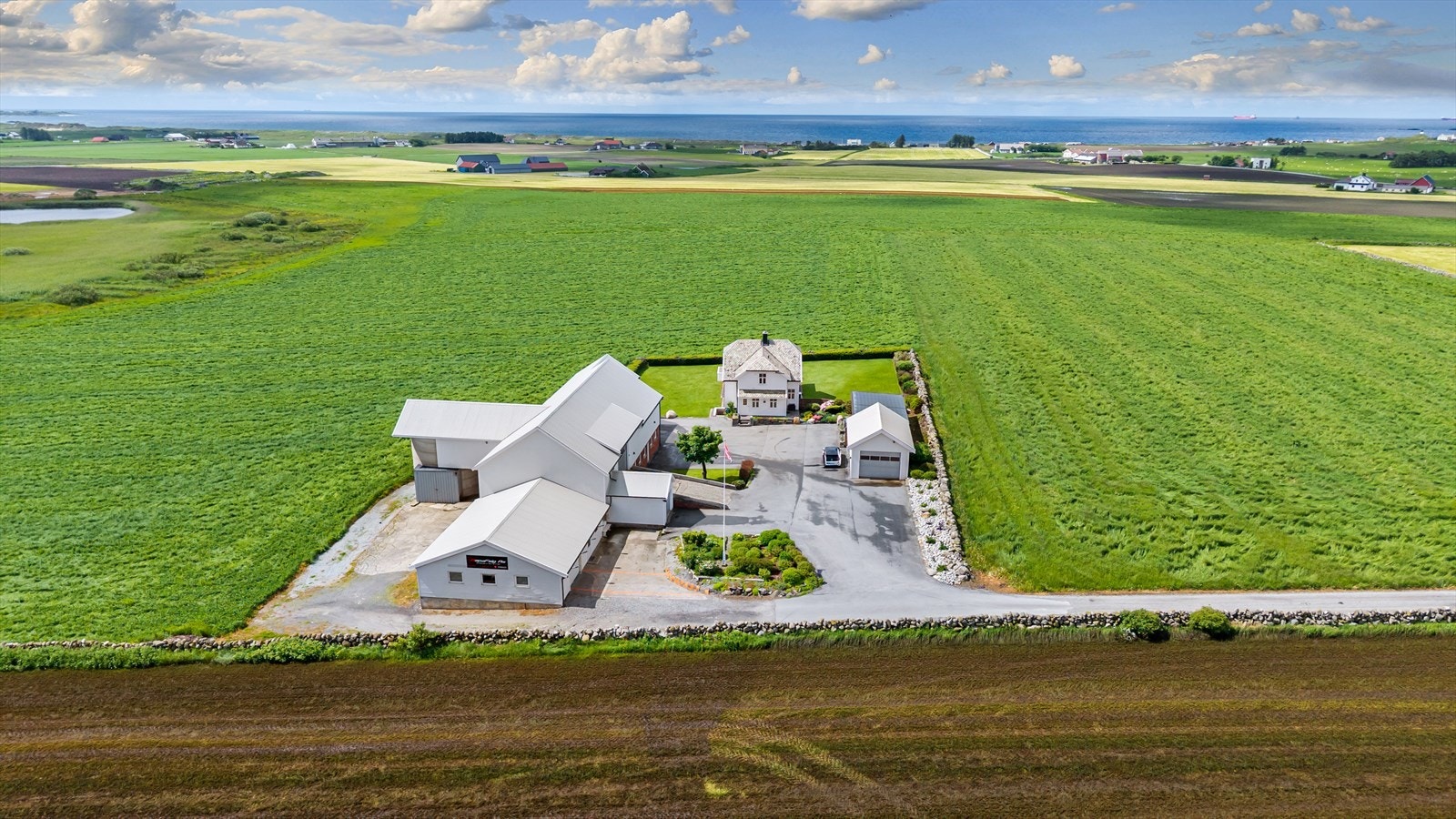 Fantastisk utsikt og svært gode solforhold! Eiendommen består av stor driftsbygning på ca. 700 kvm, hagestue med takoverbygg, garasje og enebolig. Galleribilde