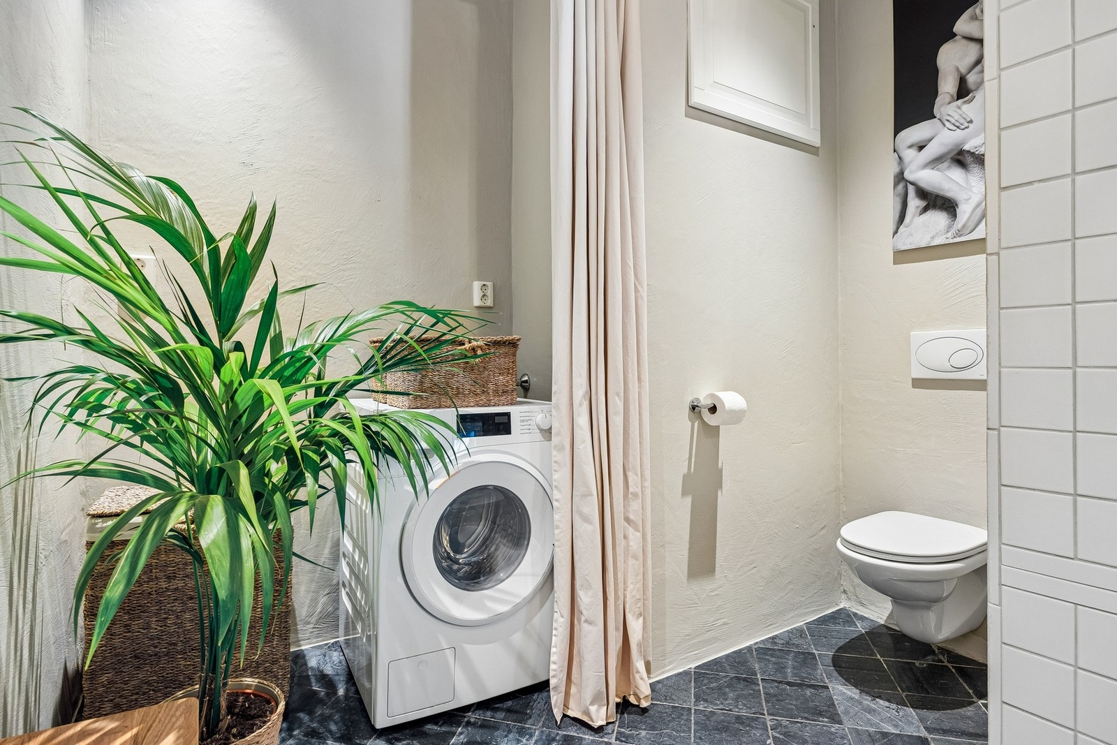 Badet har opplegg for vaskemaskin og vegghengt wc. Galleribilde