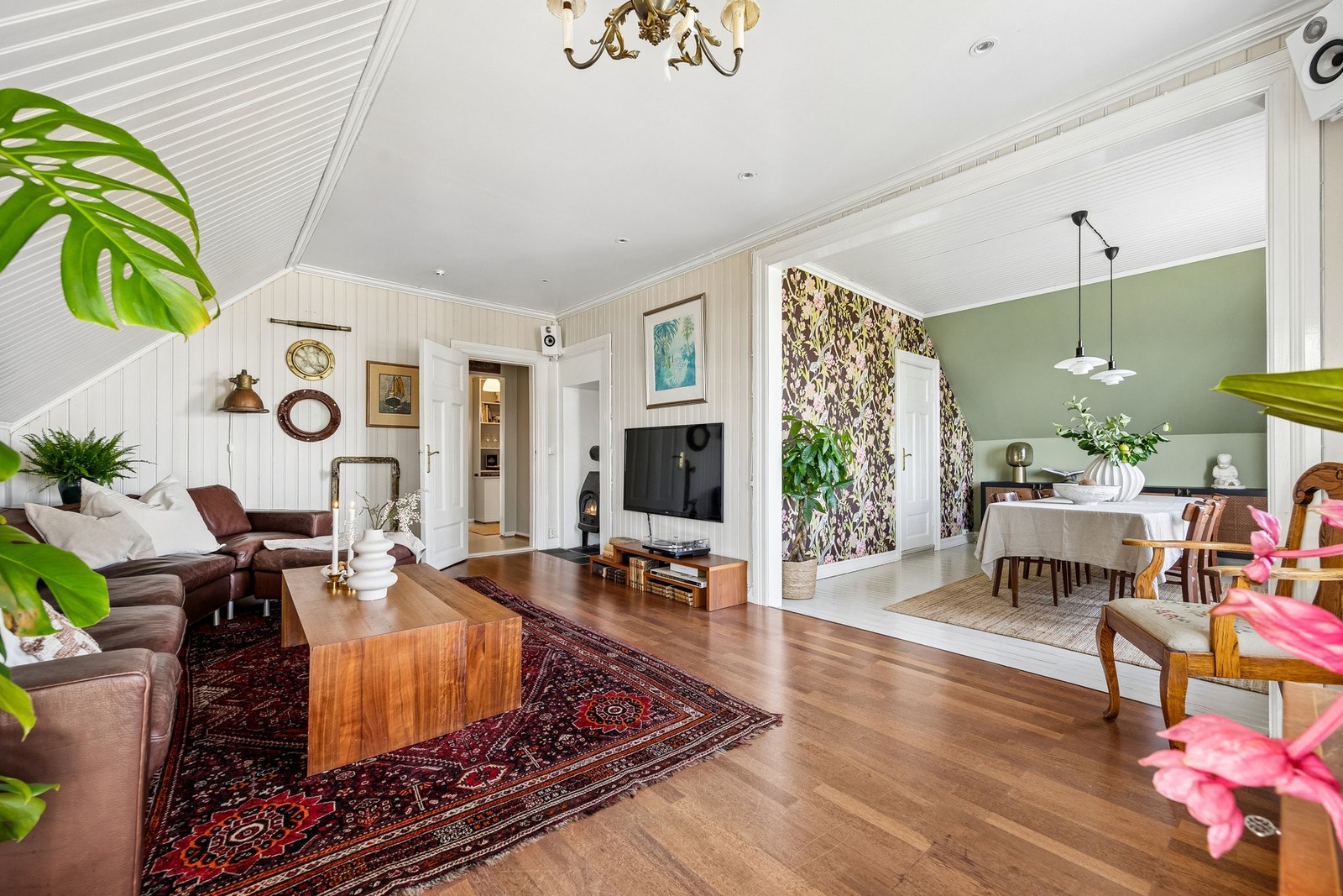 Stue og spisesute med vedovn, downlights, og utgang til balkong, samt tårnrom. Galleribilde