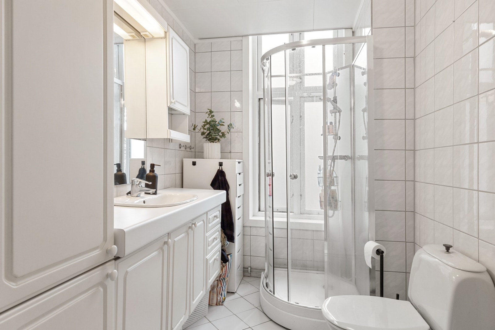 Badet er av eldre dato og innredet med servant, toalett og dusjkabinett. Galleribilde