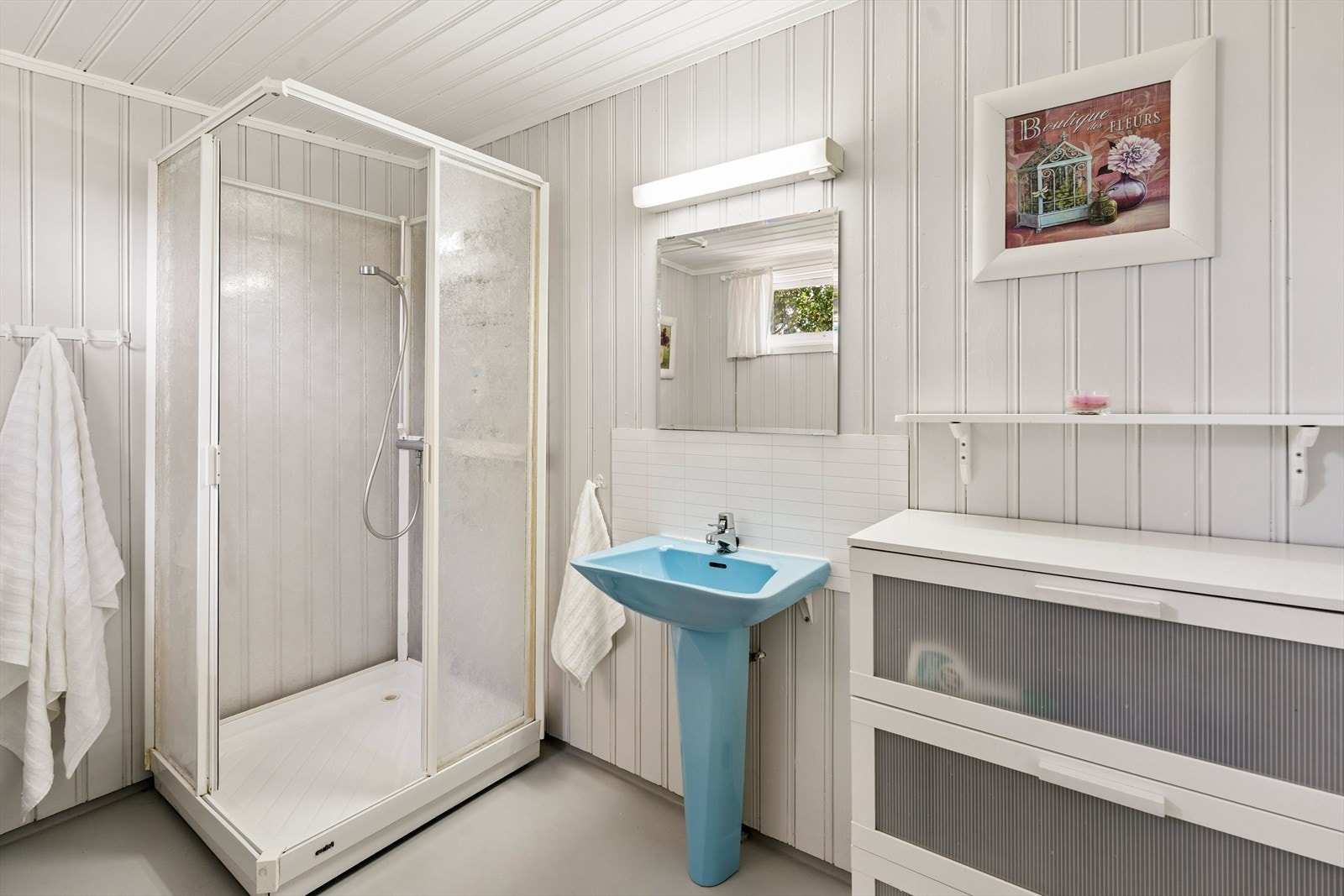 Badet er fra 1990 og har et oppgraderingsbehov. Rommet er utstyrt med dusjkabinett, servant med speil over innredning og varmekabler i gulv. Galleribilde