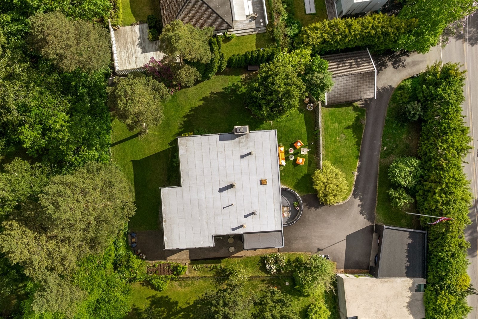Oversiktsbilde over eiendommen. Huset ligger tilbaketrukket fra veien. Galleribilde
