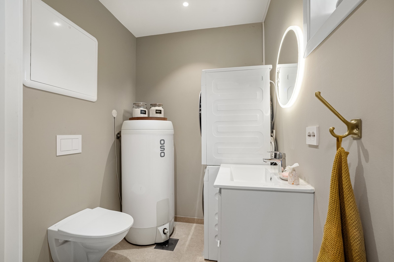 Praktisk, flislagt vaskerom med gulvvarme. Vaskerommet har plass til både vaskemaskin og tørketrommel, samt varmtvannsbereder (194L), servantskap med vask og vegghengt toalett. Galleribilde