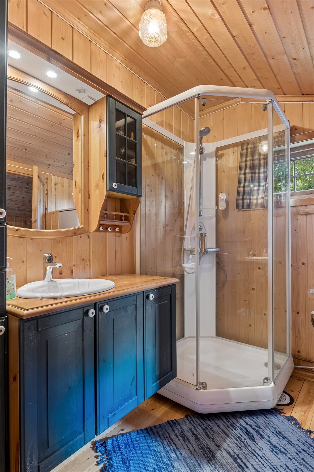 Badet er utstyrt med servant i innredning, speil og dusjkabinett. Galleribilde