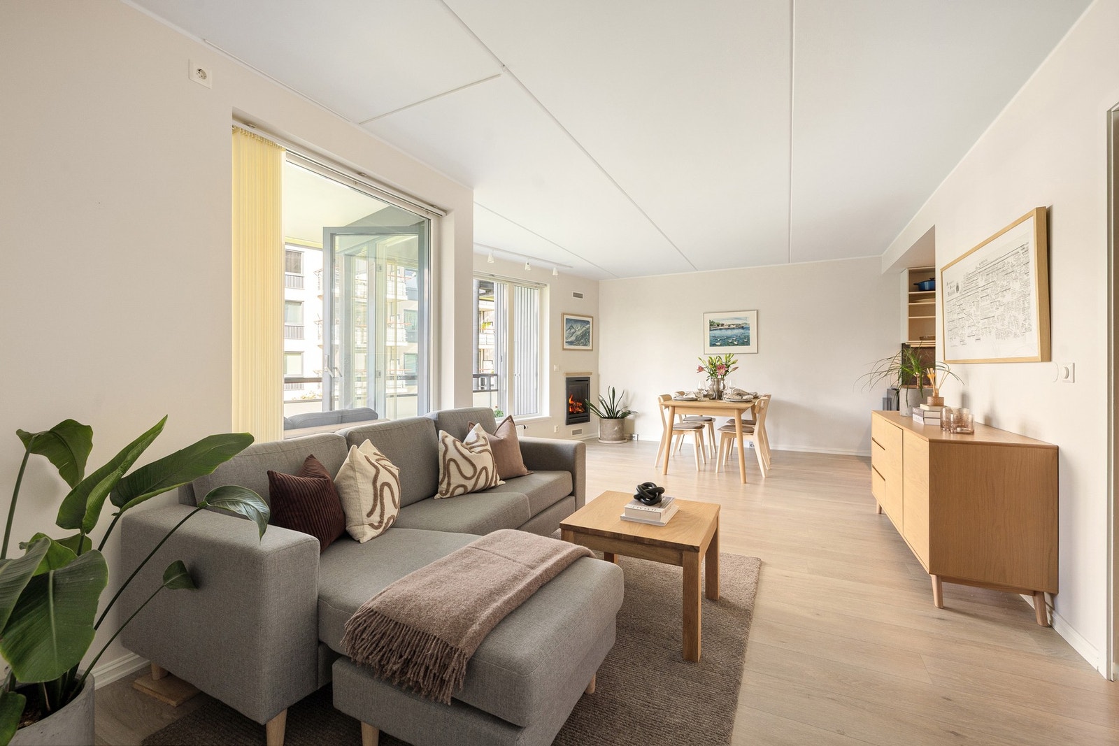 Her får du en lys og romslig stue med store vinduer og grønt utsyn. Galleribilde