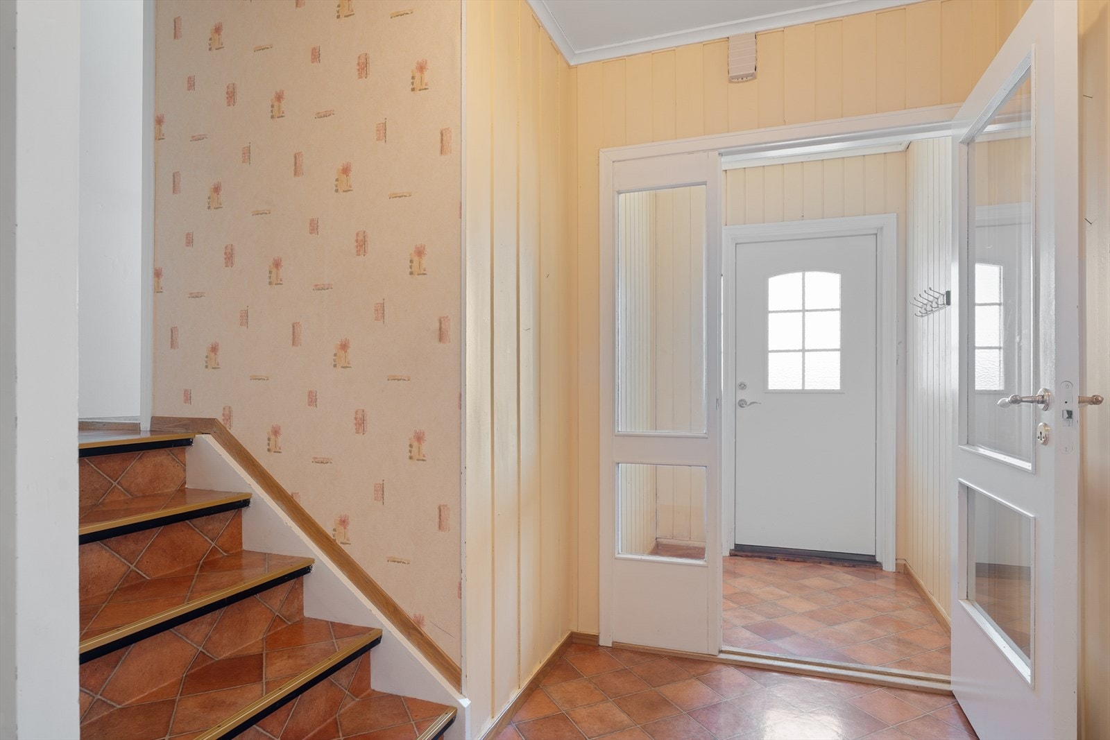 Vindfanget og hallen gir et fint førsteinntrykk. Her er god plass til yttertøy og sko. Trapp opp til soveromsfløyen. Galleribilde