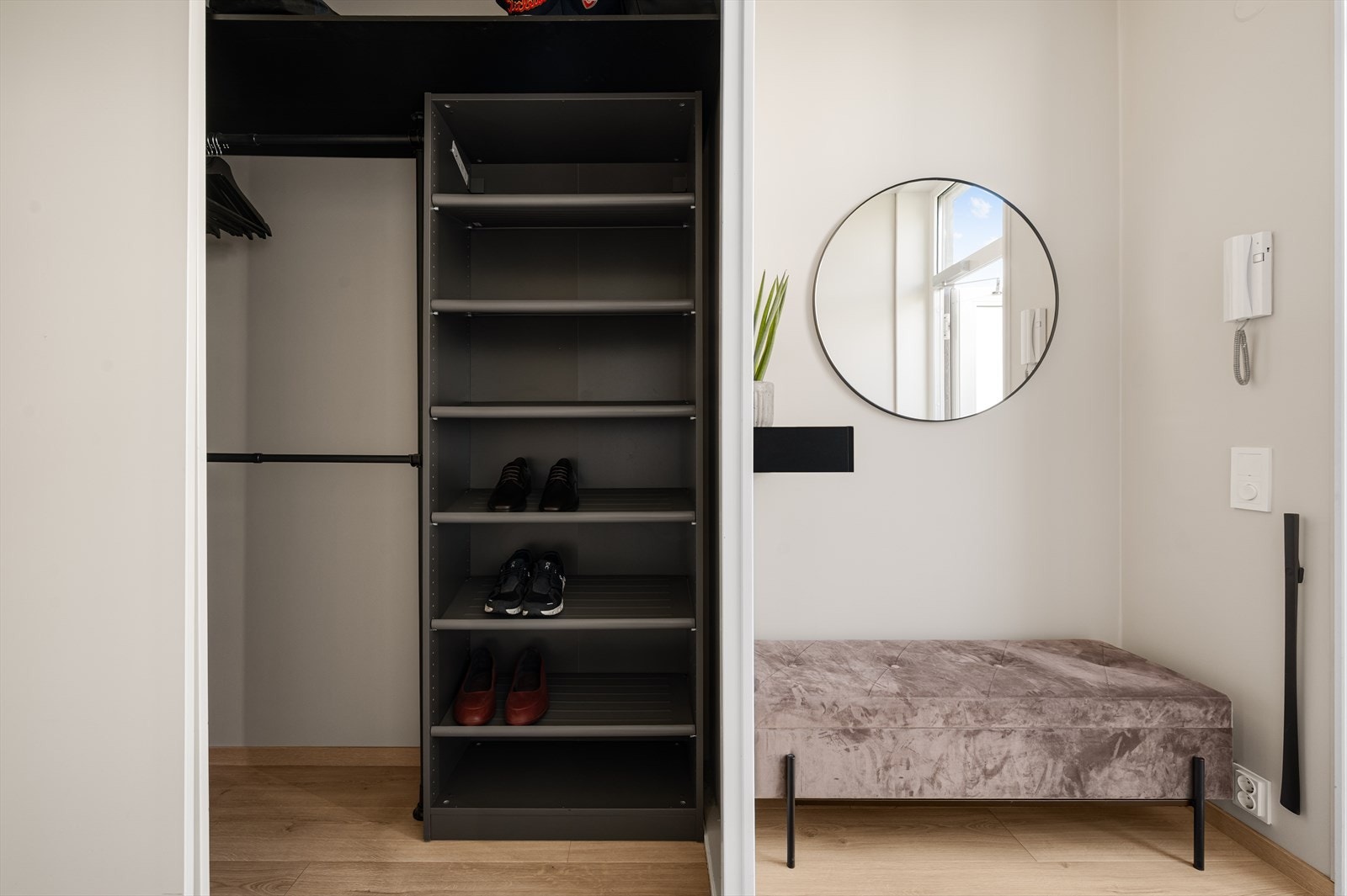 Garderobeløsningen ligner en walk-in garderobe med praktiske hyller og klessoppheng. Galleribilde