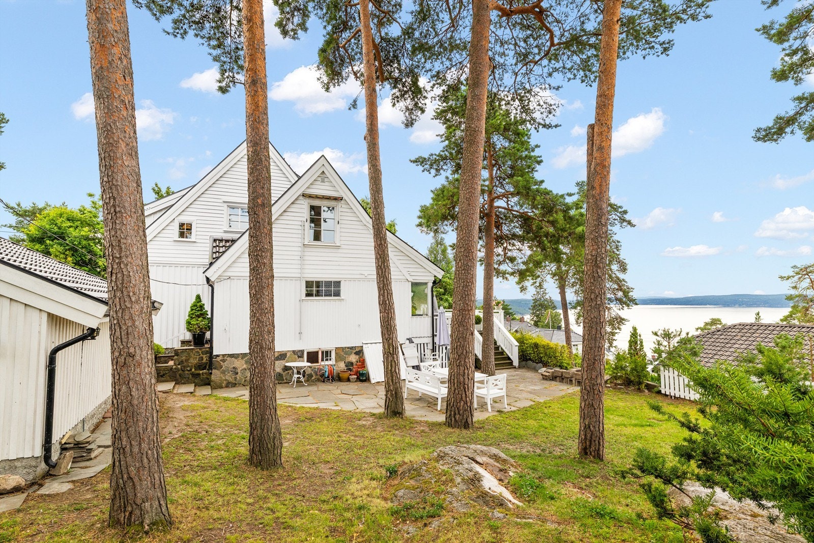 Solrik og usjenert tomt med fjordutsikt, som er pent opparbeidet med bl.a. plenareal, beplantning og noe naturtomt Galleribilde