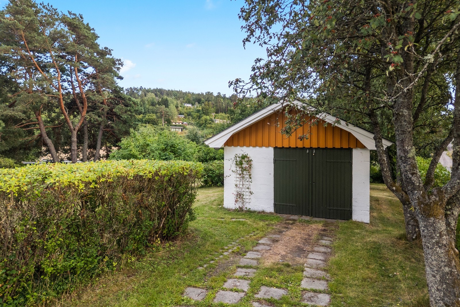 Frittstående garasje med god lagringsplass i tilknyttede boder. Galleribilde