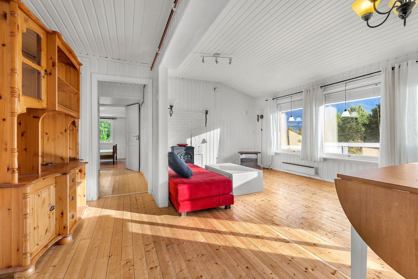 Stuen har gjennomgående furugulv og panel på vegger og i tak. Galleribilde