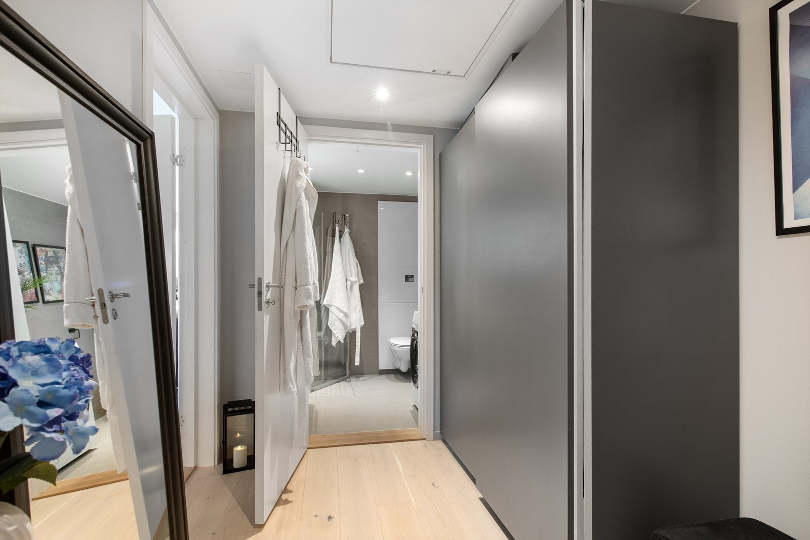 Innbydende entré med praktisk skyvedørsgarderobe og adkomst til leilighetens øvrige rom. Galleribilde