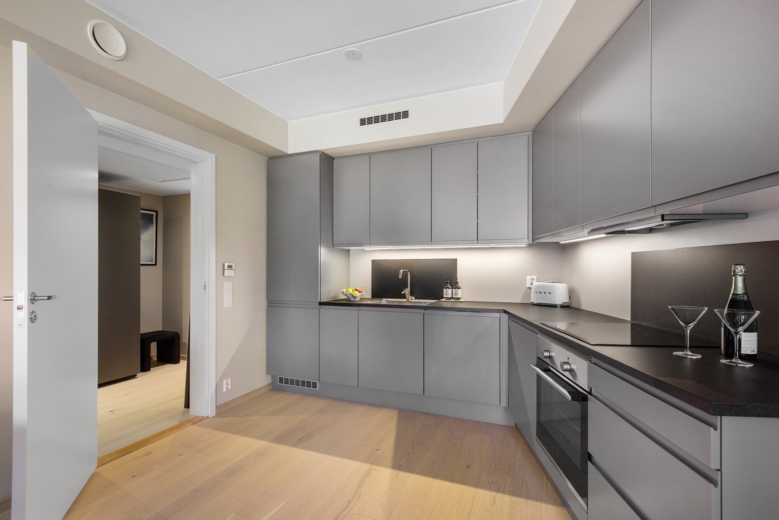 Moderne kjøkkeninnredning med glatte fronter og laminat benkeplate. Galleribilde