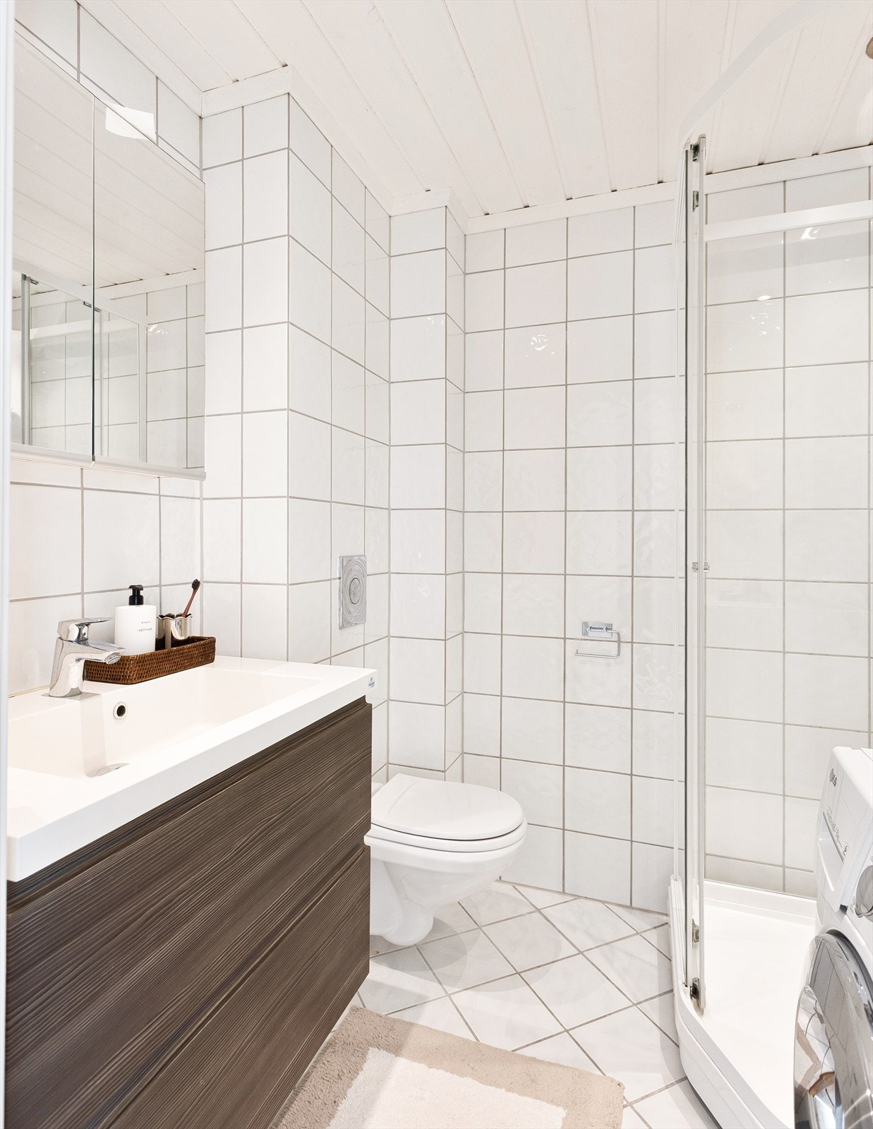 Badet er lyst og romslig, med flislagte gulv og vegger i en tidløs lys utførelse. Galleribilde