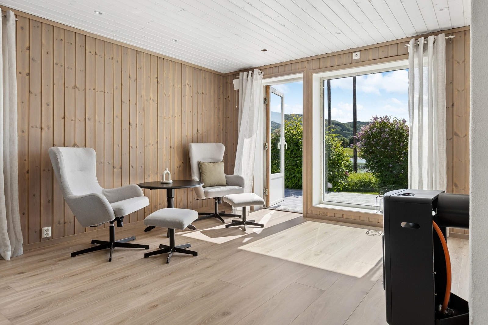 Stuen har utgang til en stor terrasse som strekker seg rundt boligen. Galleribilde