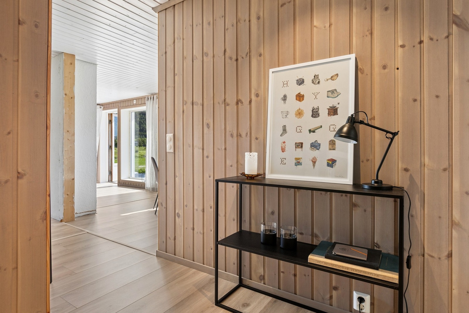 Entré med panelkledde vegger som leder inn til boligens oppholdsrom. Galleribilde