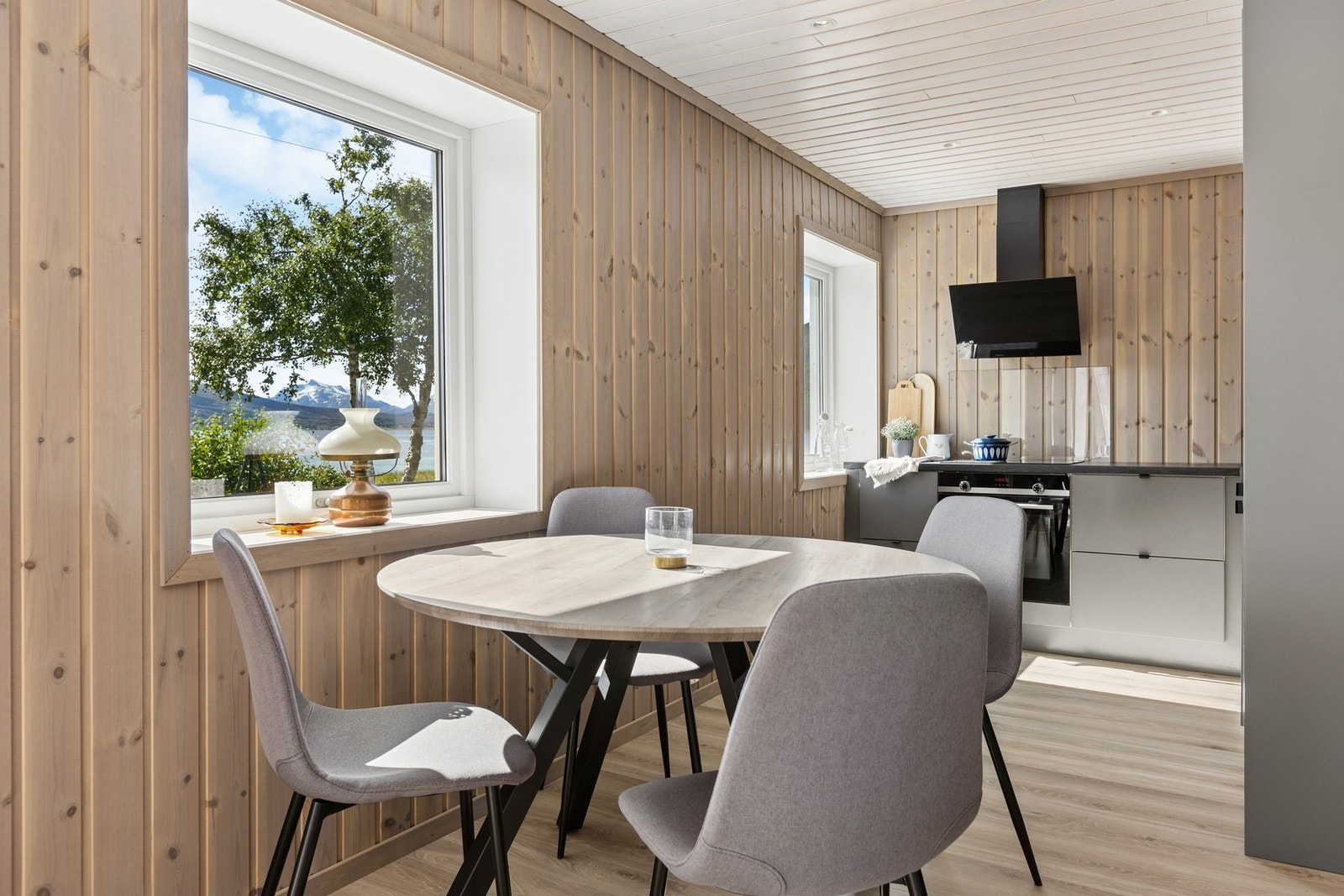 Spisestue i åpen løsning med kjøkkenet, med nydelig utsikt mot sjøen. Galleribilde
