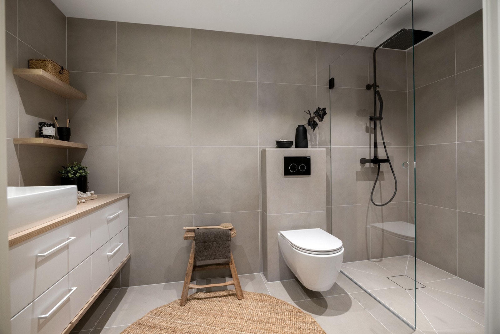 Badet har elektrisk gulvvarme og en stilren dusjsone som gir god utnyttelse av arealet. Delikat bad! Galleribilde