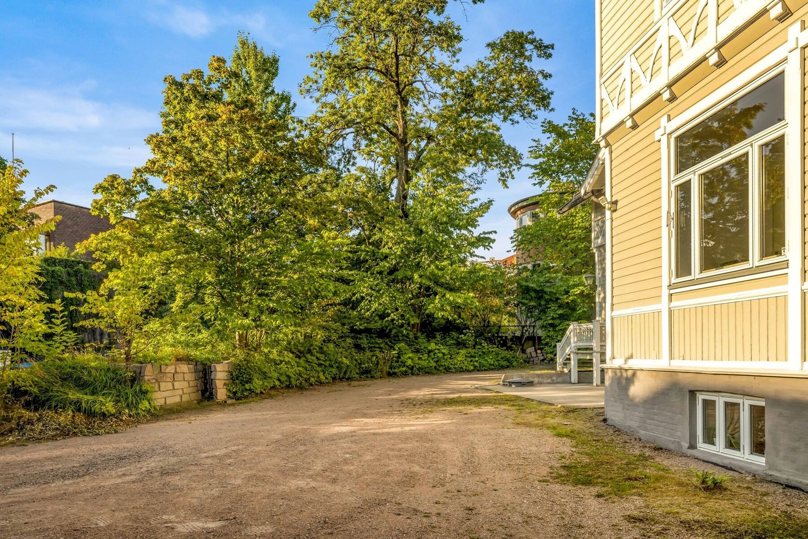 Eiendommen er omkranset av flotte trær og beplantning. Galleribilde