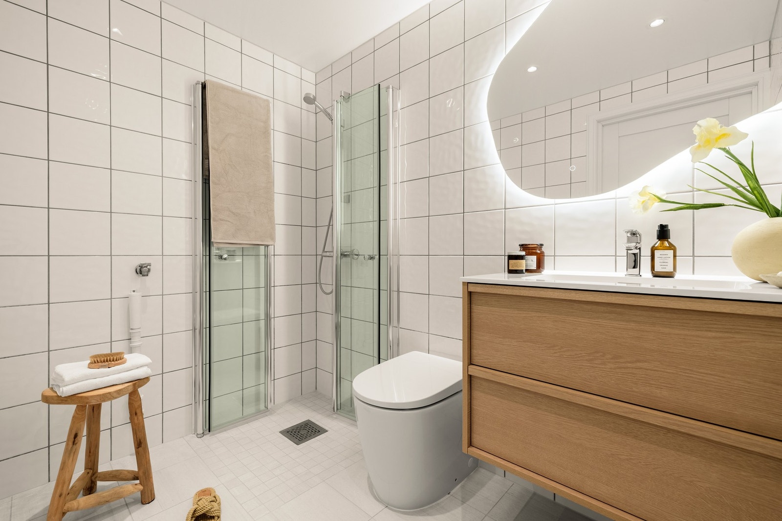 Fullt utstyrt bad med dusjhjørne, toalett, innredning med nedfelt servant, speil med lys og opplegg for vaskemaskin. Galleribilde