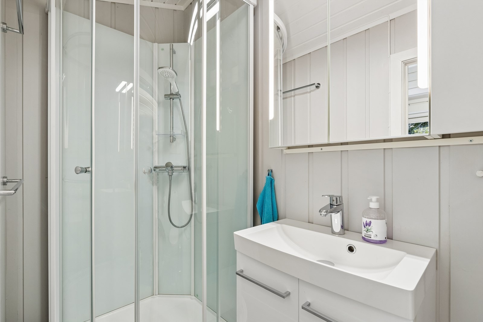 Badet er utstyrt med dusjkabinett og servant med armatur fra Grohe. Galleribilde