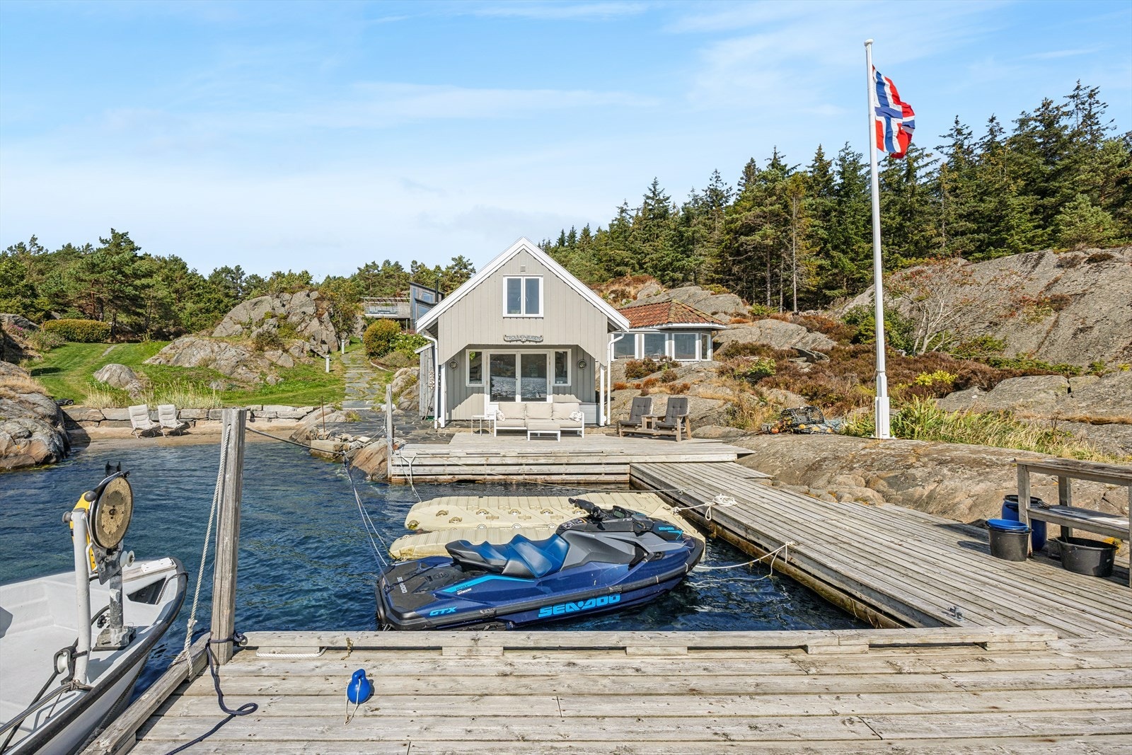 Sjøbua, bryggeanlegget og den innbydende sandstranda ligger fint til i den i flotte bukta som er omkranset av svaberg. Galleribilde