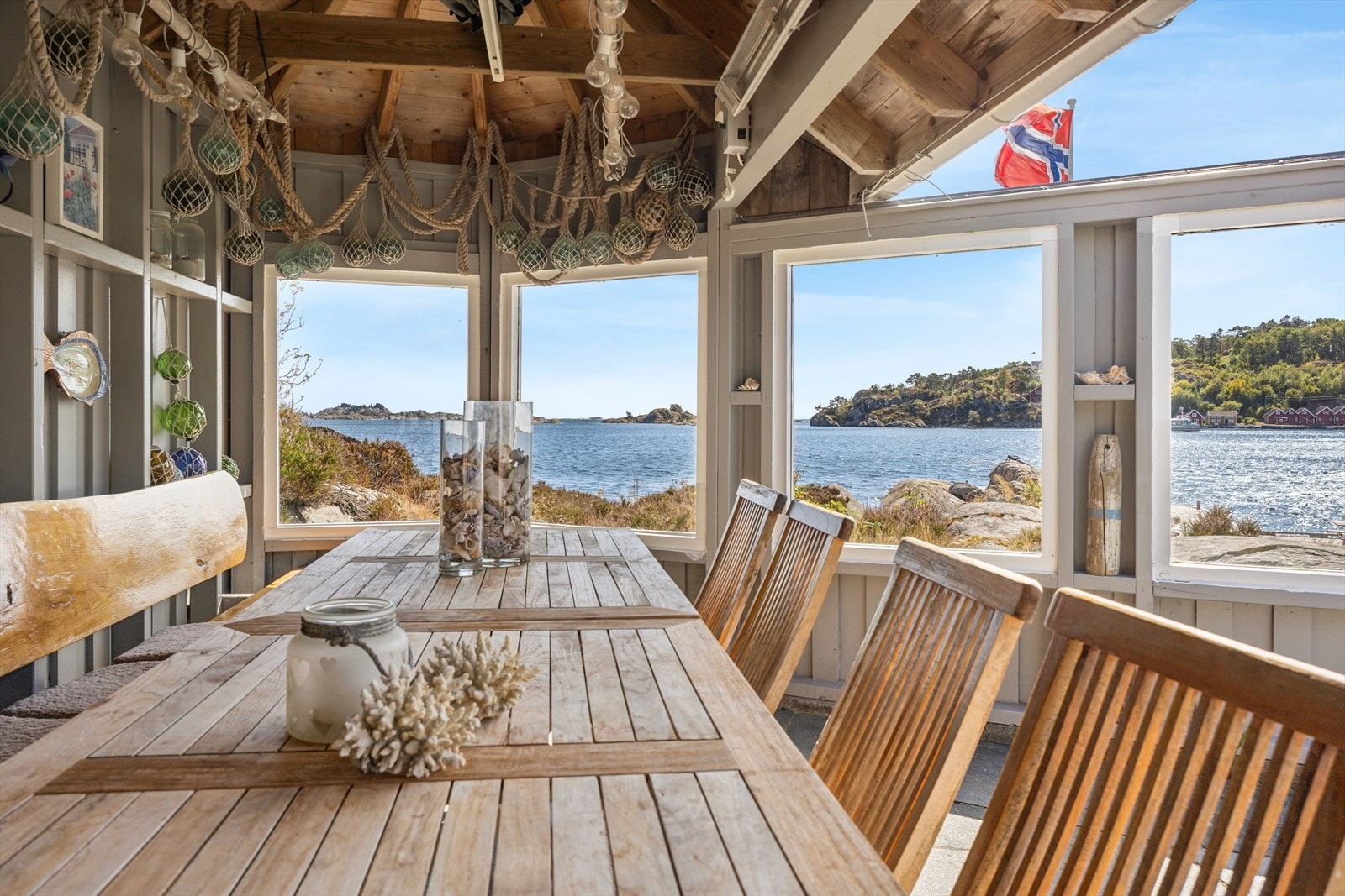 Den fine uteplassen i tilknytning til sjøbua har levegg med glass og takoverbygg. Galleribilde