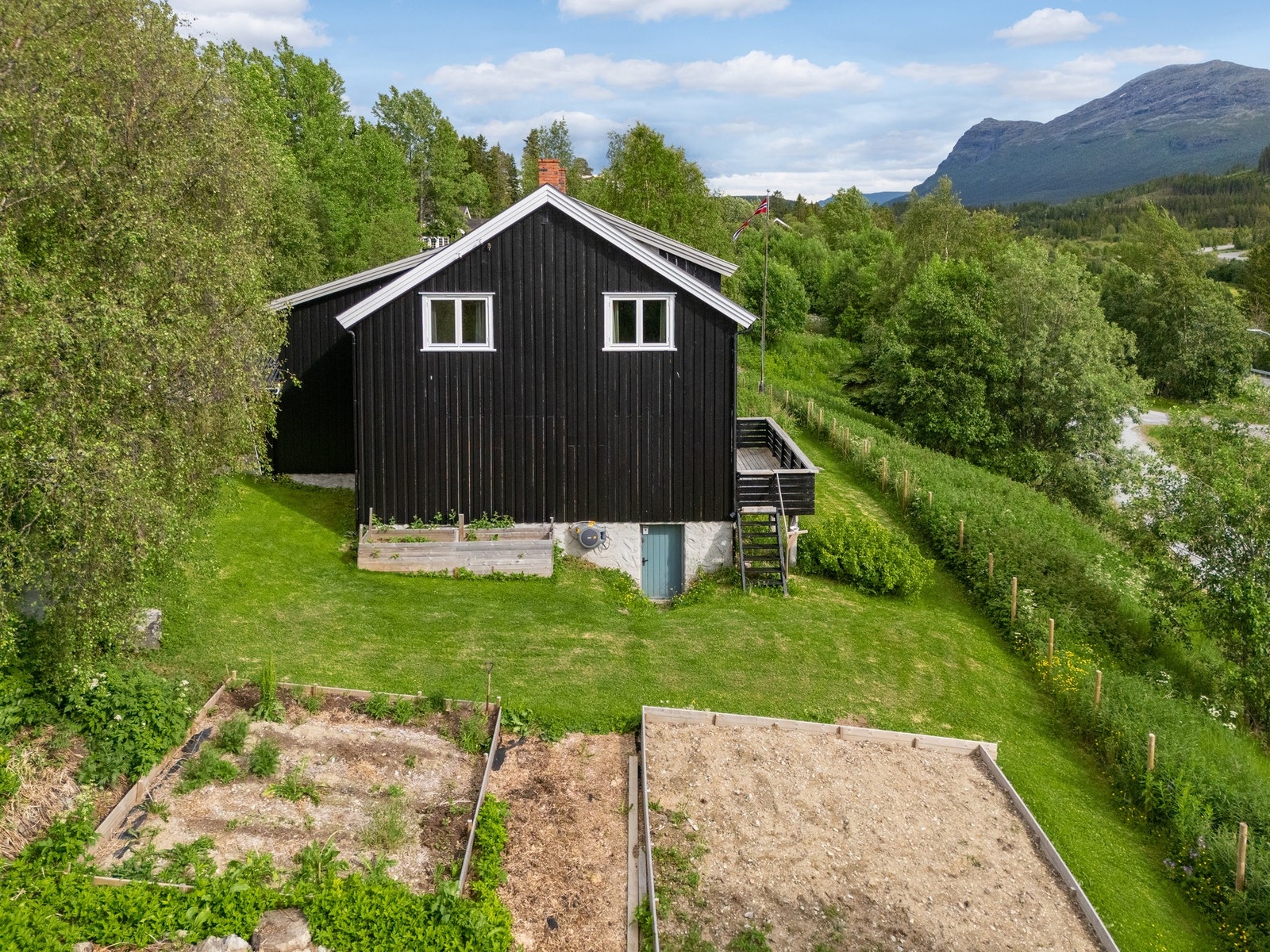 En innholdsrik eiendom med bolig, uthus og opparbeidede hagearealer. Galleribilde