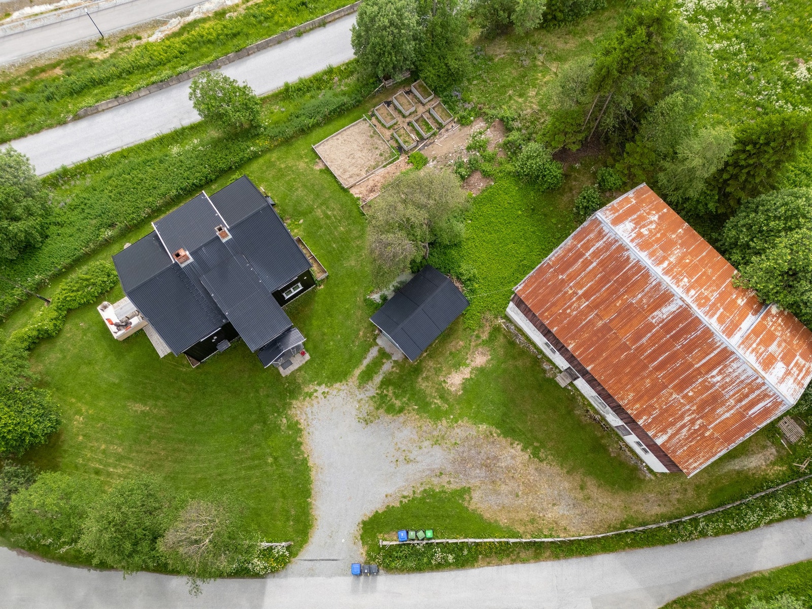 Oversiktsbilde av eiendommen med bolig, låve, uthus, gårdsplass og hage. Galleribilde