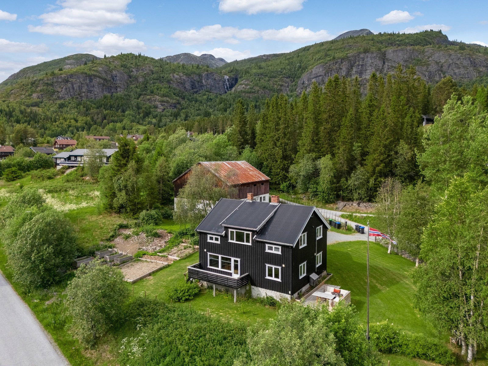 Boligen ligger grønt og fint til, med fjellene som bakteppe. Galleribilde