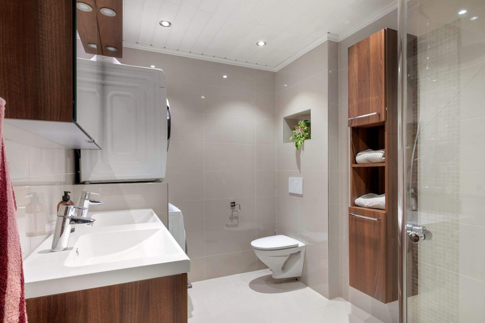 Badet er delikat og tidløst med flislagte overflater, varmekabler og downlights. Galleribilde