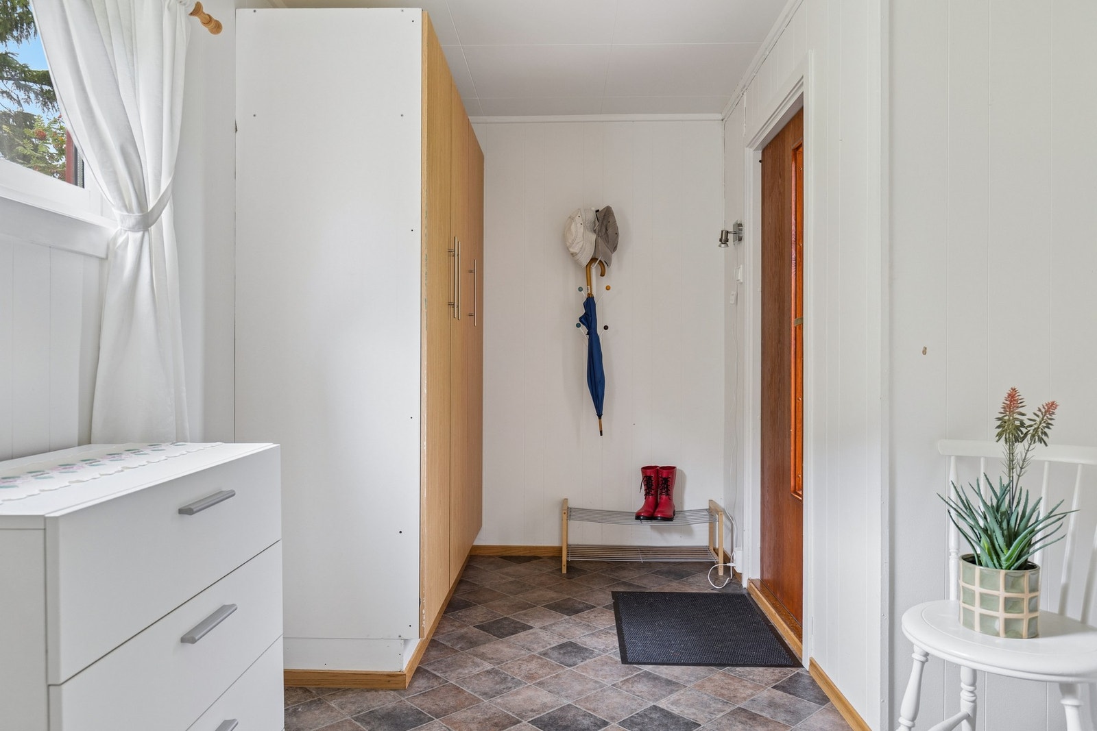 Vindfang med plass til oppbevaring av yttertøy og sko. Galleribilde
