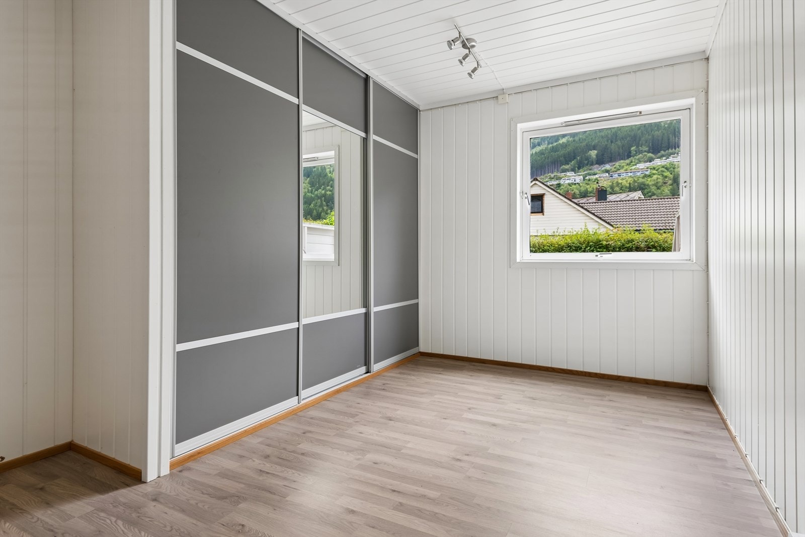 Det er et soverom i boligen. Lyst og fint med garderobe Galleribilde