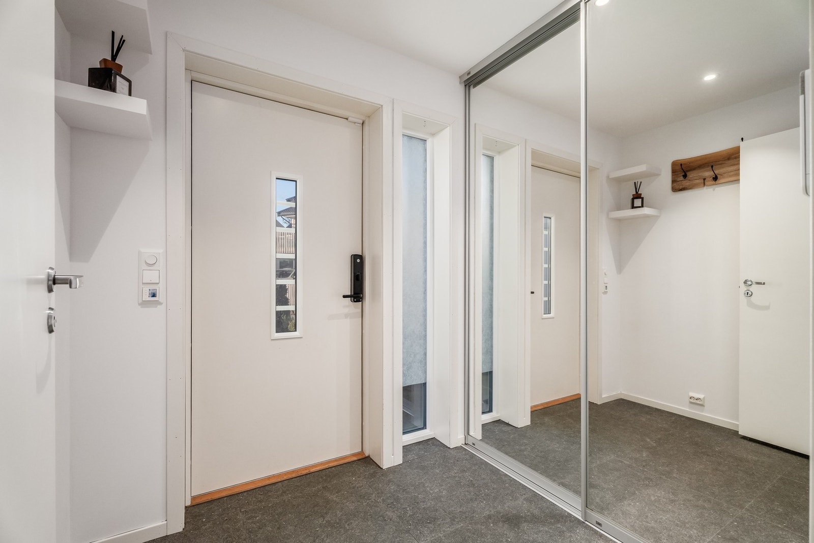 Entré med varmekabler i gulvet og praktisk skyvedørsgarderobe med helfigurspeil, som holder ytterklær og sko ute av syne. Galleribilde