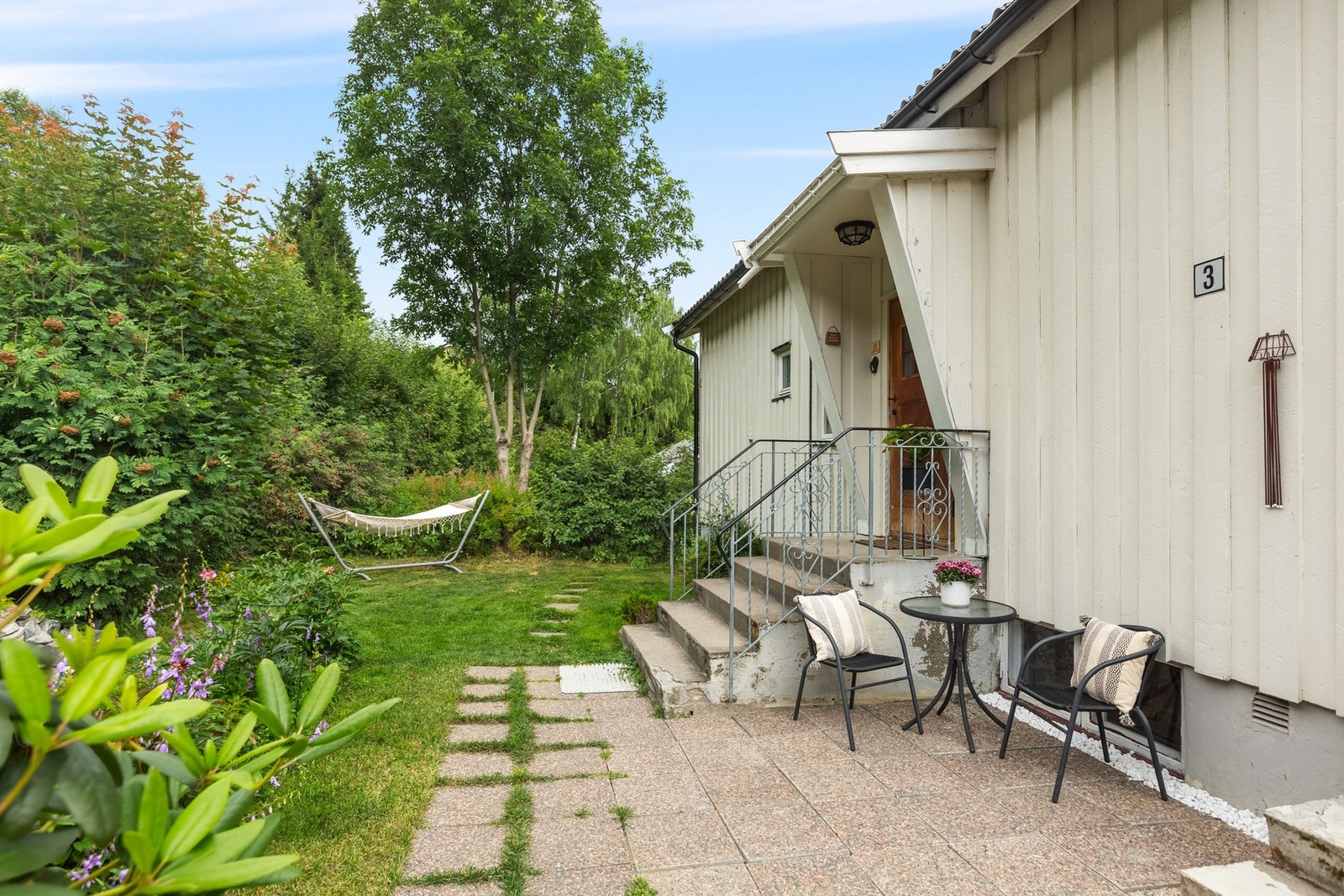 Overbygd inngangsparti, med pent opparbeidet uteområde. Galleribilde
