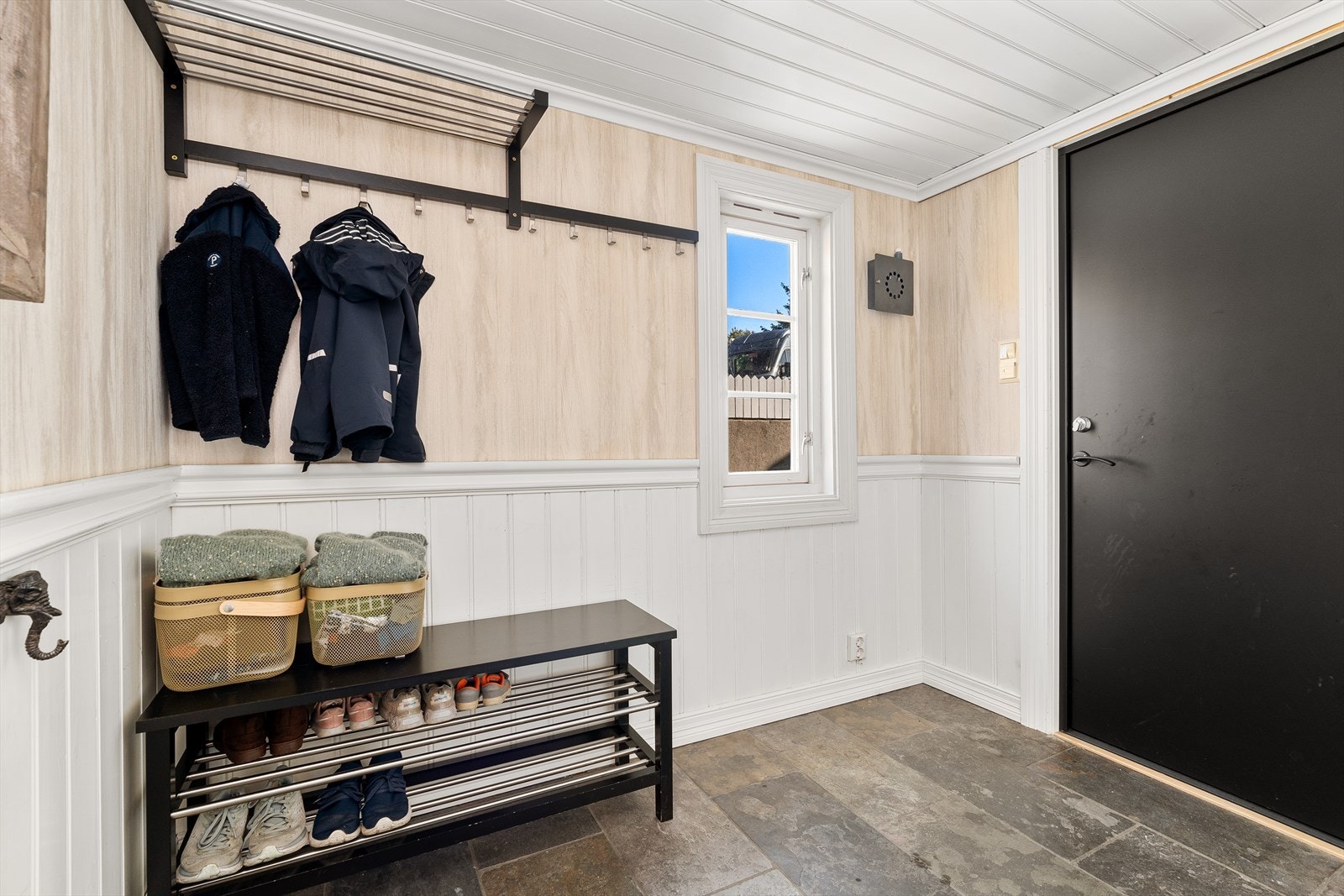 Velkommen inn! I entreen er det flislagt og plass til å henge fra seg yttertøy og sko. Ytterdøren er av nyere dato og er blitt skiftet av nåværende eier. Galleribilde