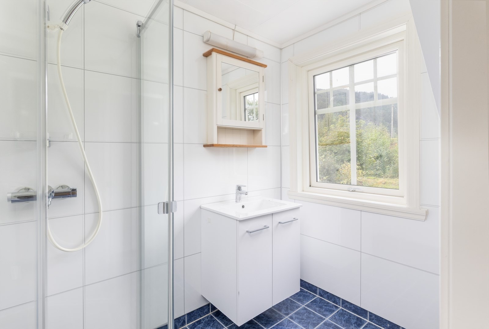 Badet i 2. etasje har baderomsplater på veggene og keramiske fliser på gulvet med varmekabler. Galleribilde
