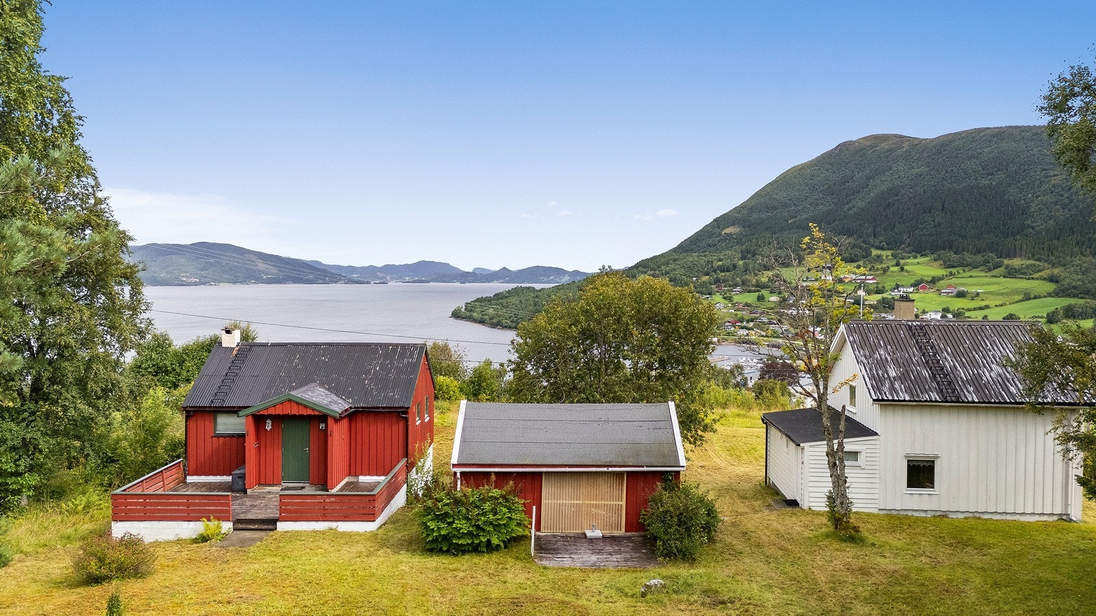 Fasade vest, rød hytte og opprinnelig hovedhus (hvitt bygg) Galleribilde