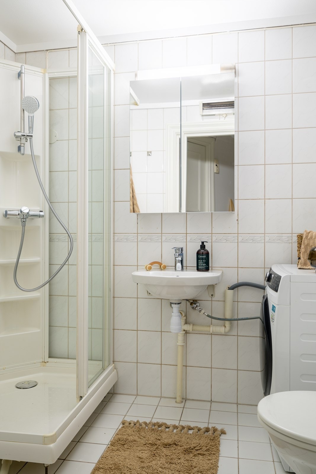 Videre er rommet innredet med dusjkabinett, klosett, speilskap og servant. Galleribilde