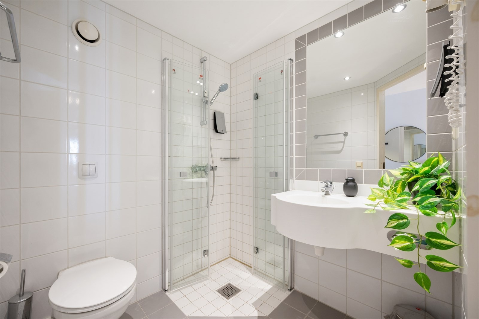 Dusjhjørne med nye innfellbare dusjvegger i herdet glass. Downlights i taket. Galleribilde