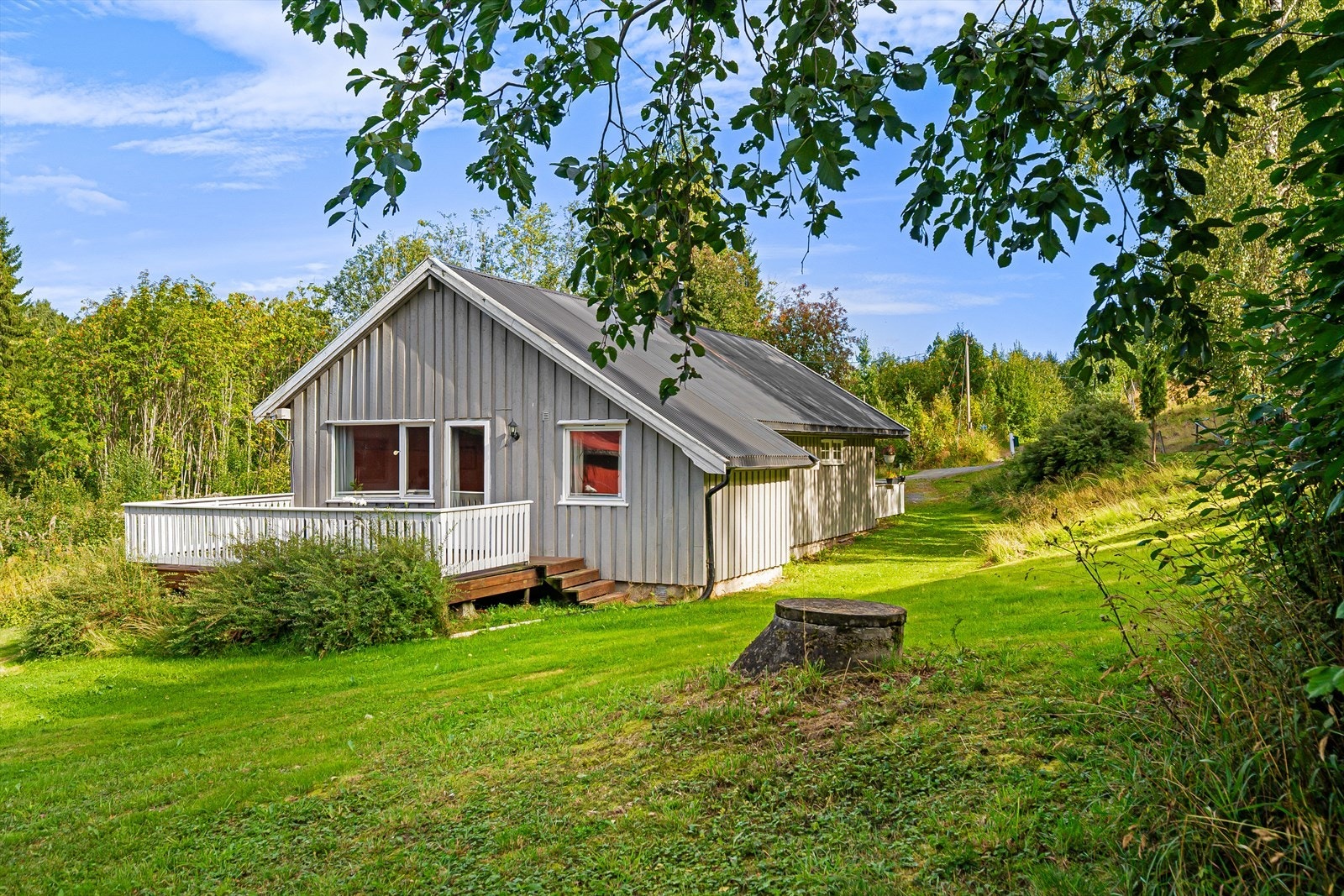 Fra terrassen er det trapp ned til hagen som er opparbeidet med plen og variert beplantning. Galleribilde