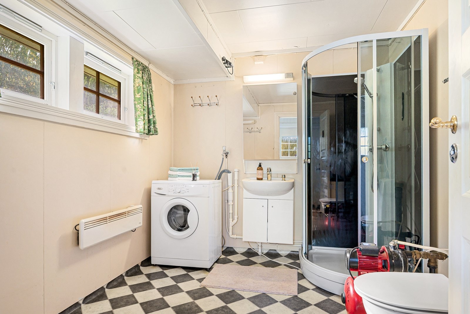 Baderommet er utstyrt med lyst servantskap, speil med belysning over, dusjkabinett, toalett og opplegg for vaskemaskin. Galleribilde