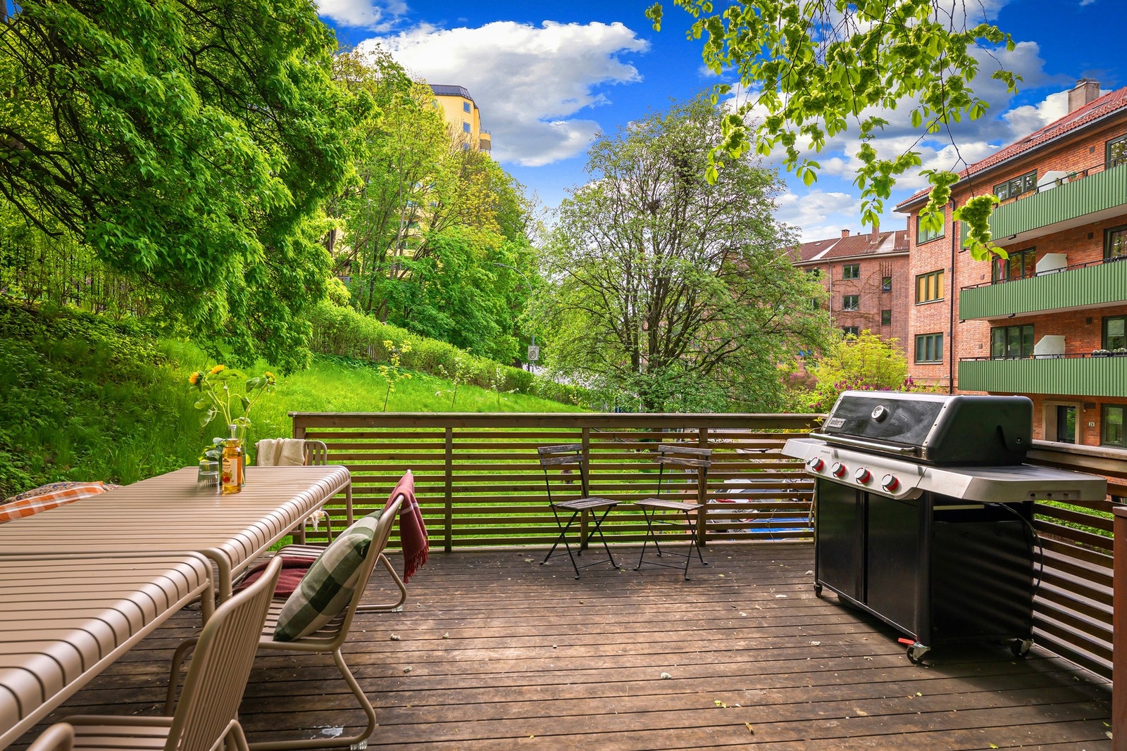 Frodige fellesarealer for beboerne med store spisebord og grill Galleribilde