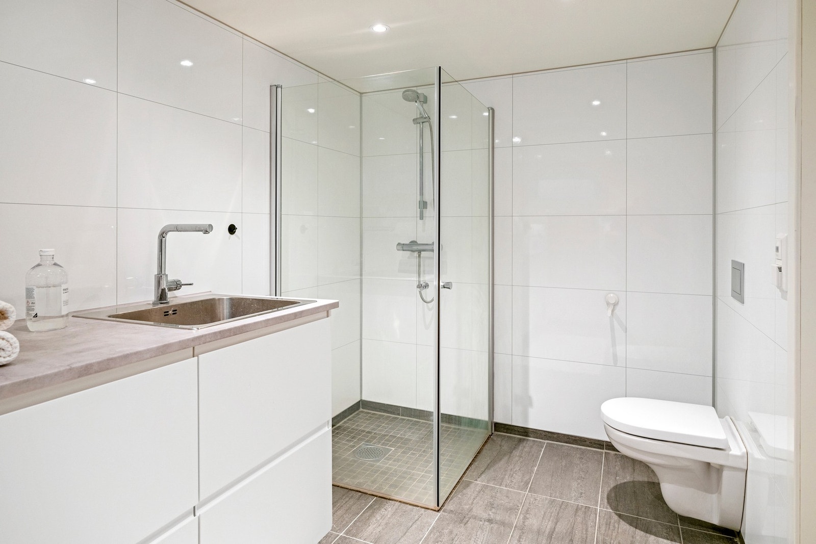 Dusjhjørnet har foldbare glassvegger som gir god plass når dusjen ikke er i bruk, mens vegghengt toalett bidrar til et ryddig og moderne uttrykk. Galleribilde