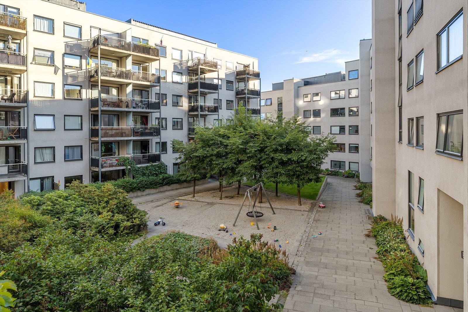 Frodig og pent opparbeidet bakgård med plen, internveier og beplantning. Galleribilde