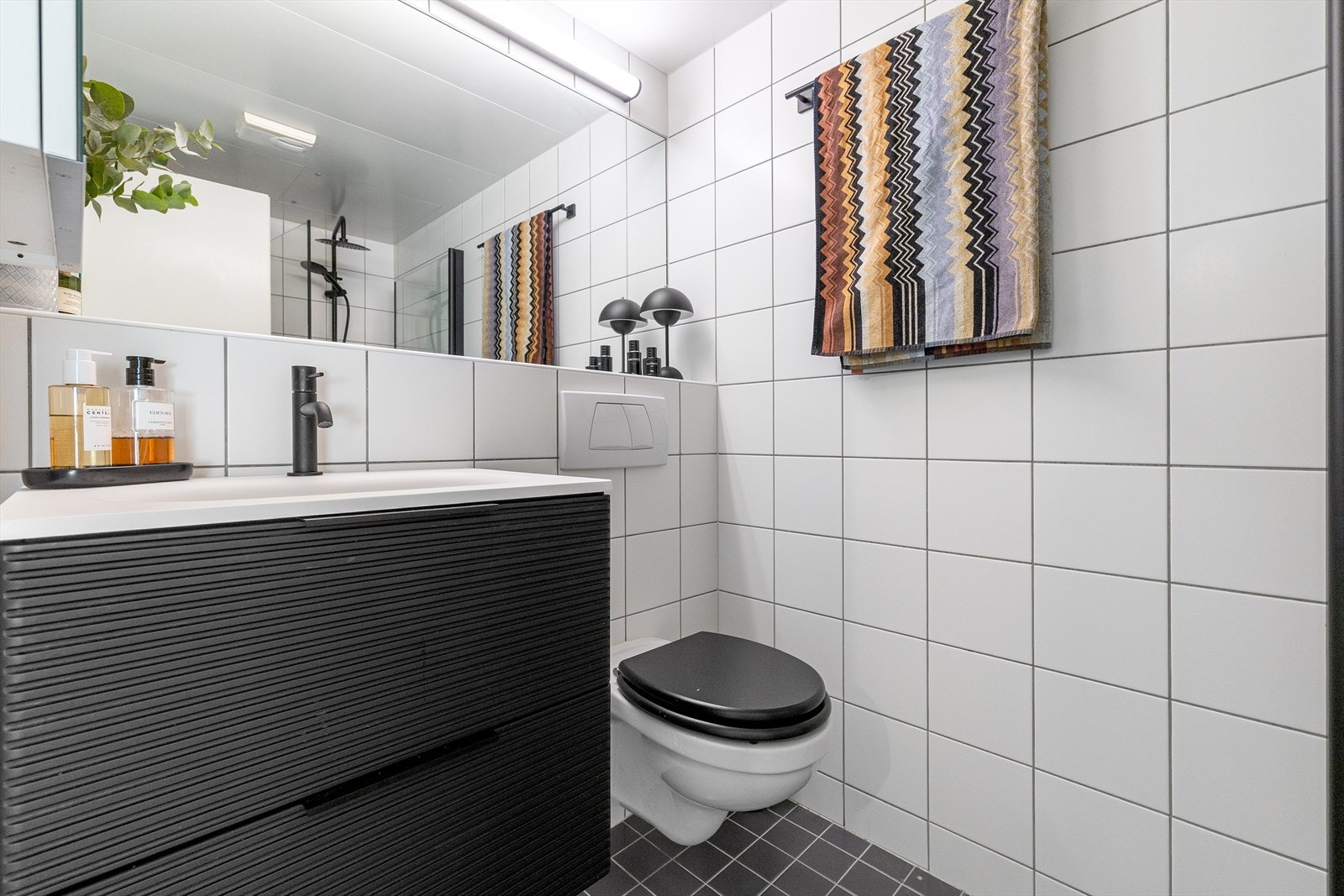 Badet har flislagte overflater og behagelig gulvvarme. Det er opplegg for vaskemaskin og mekanisk ventilasjon. Galleribilde