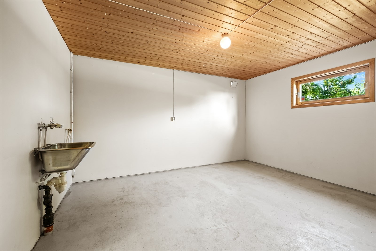 Praktisk bod med utslagsvask og betonggulv. Galleribilde