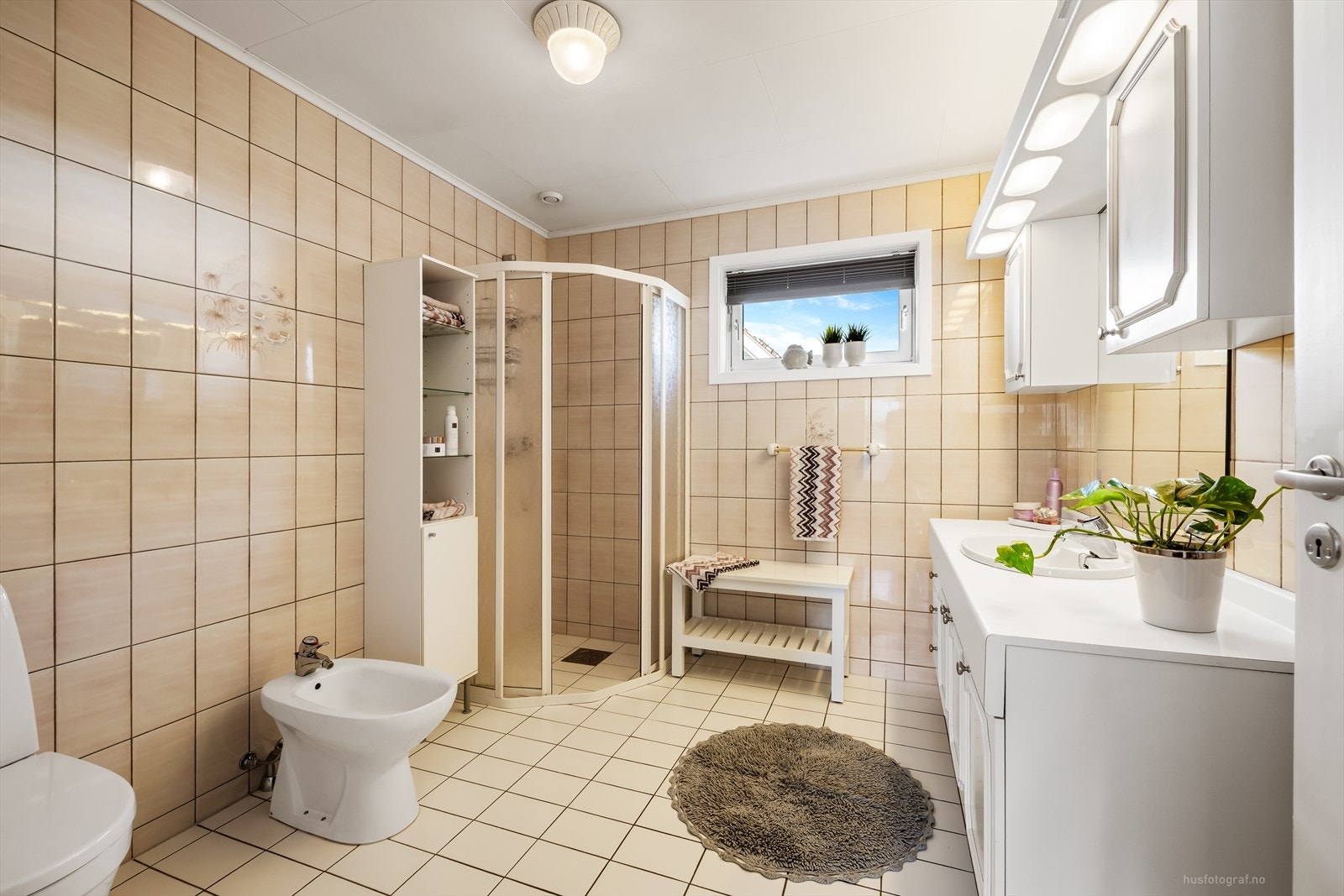 Badet er fra byggeår med flislagte vegger og malte ruteplater i innvendig tak. Flislagt gulv med elektriske varmekabler styrt via termostat. Galleribilde